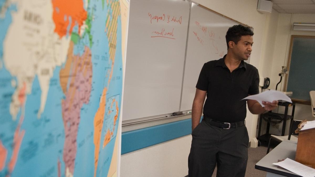 教授讲课旁边是白板和世界地图